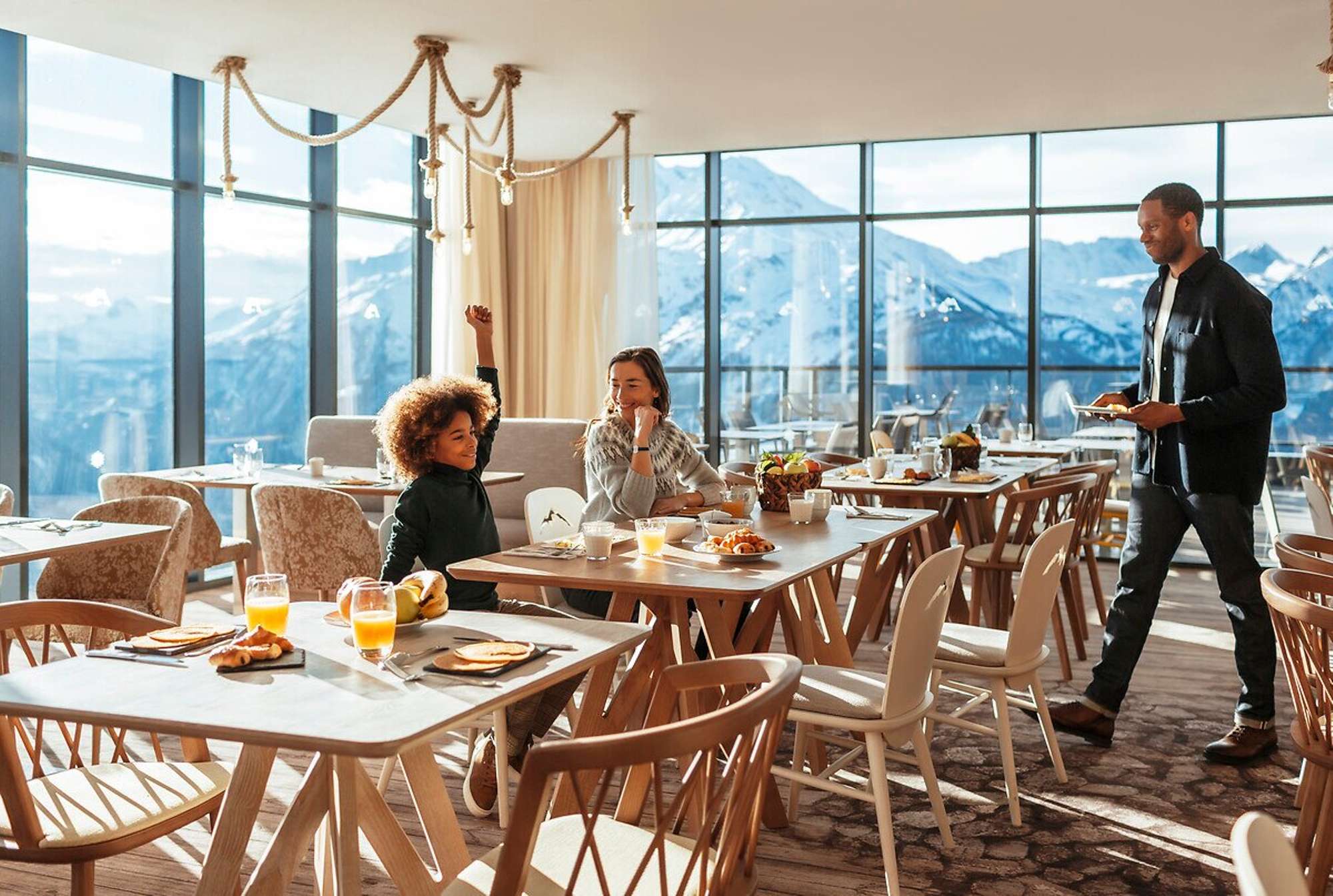 Shared dining area with floor-to-ceiling windows and panoramic mountain views
