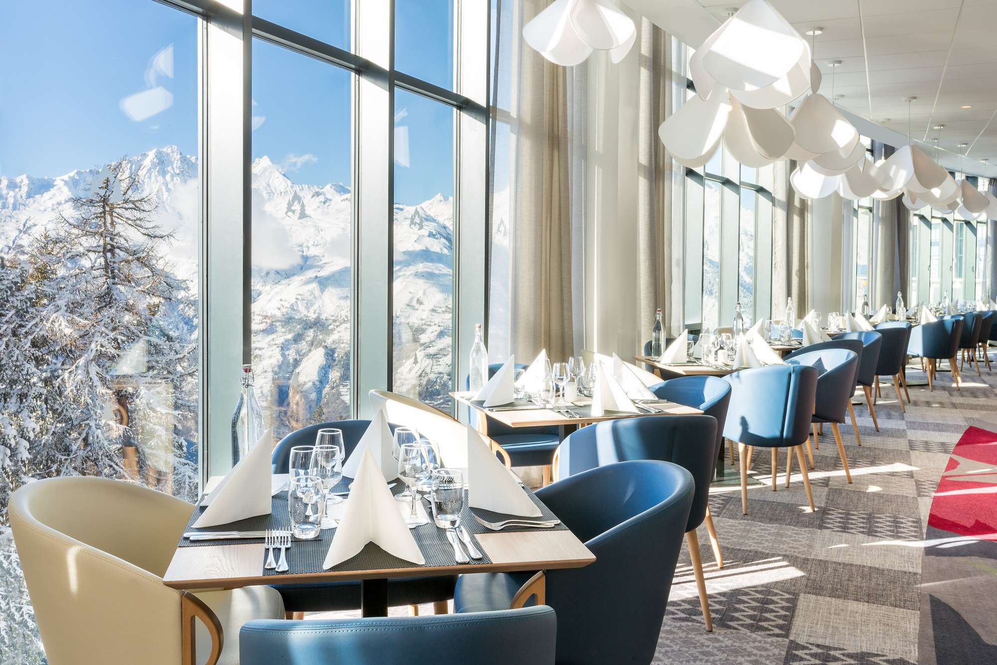 Dining area with floor-to-ceiling windows and panoramic mountain views