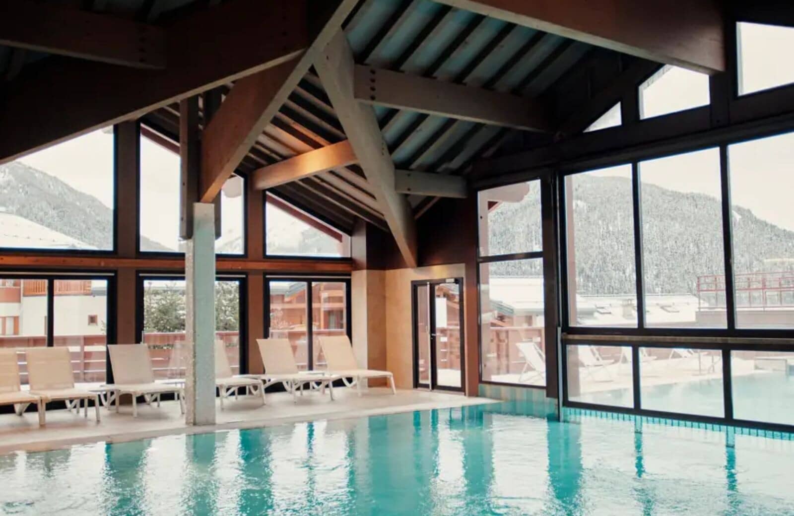 Indoor heated pool with mountain views and outdoor sun deck access
