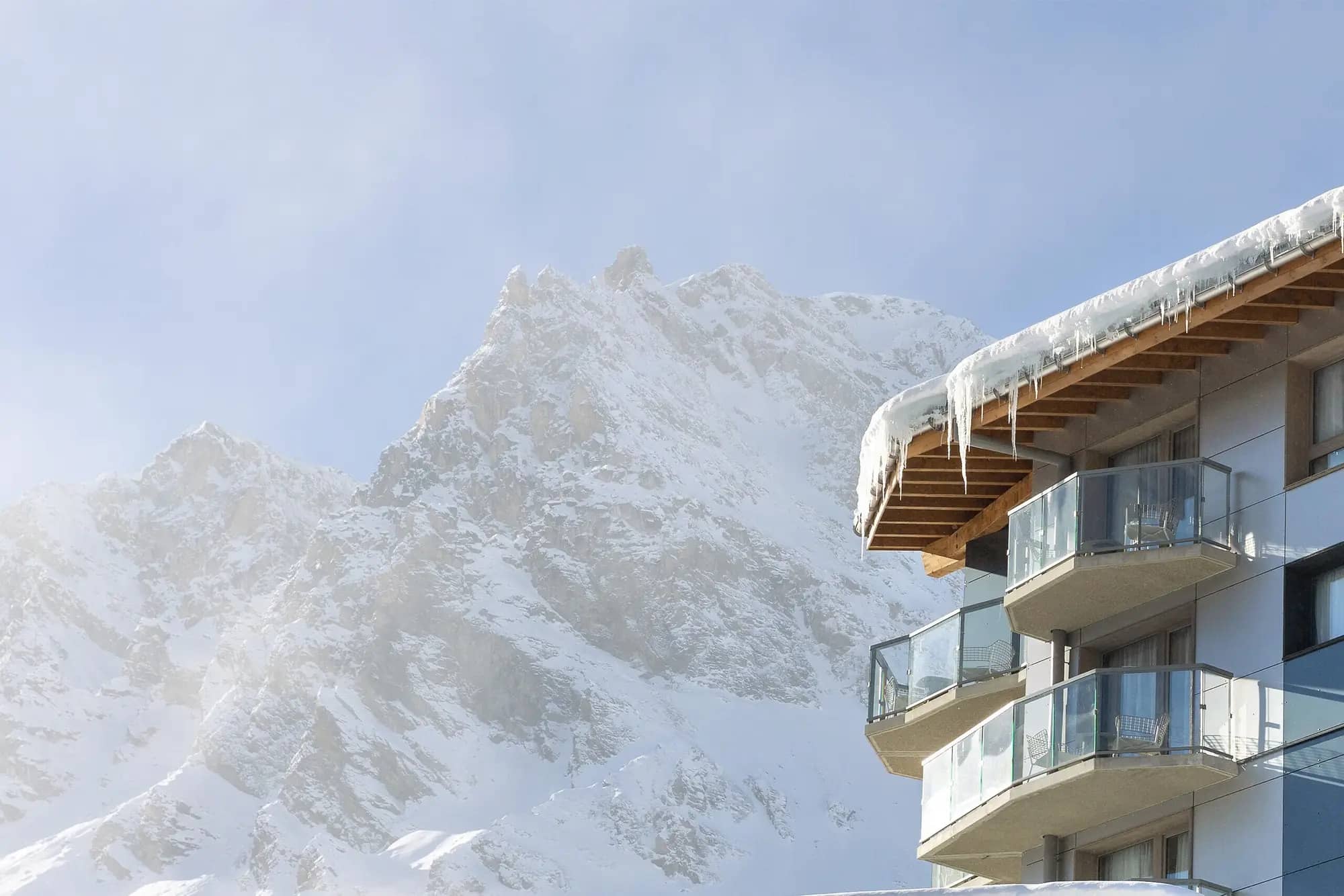 Private balconies with glass railings; direct views of snowy mountain peak