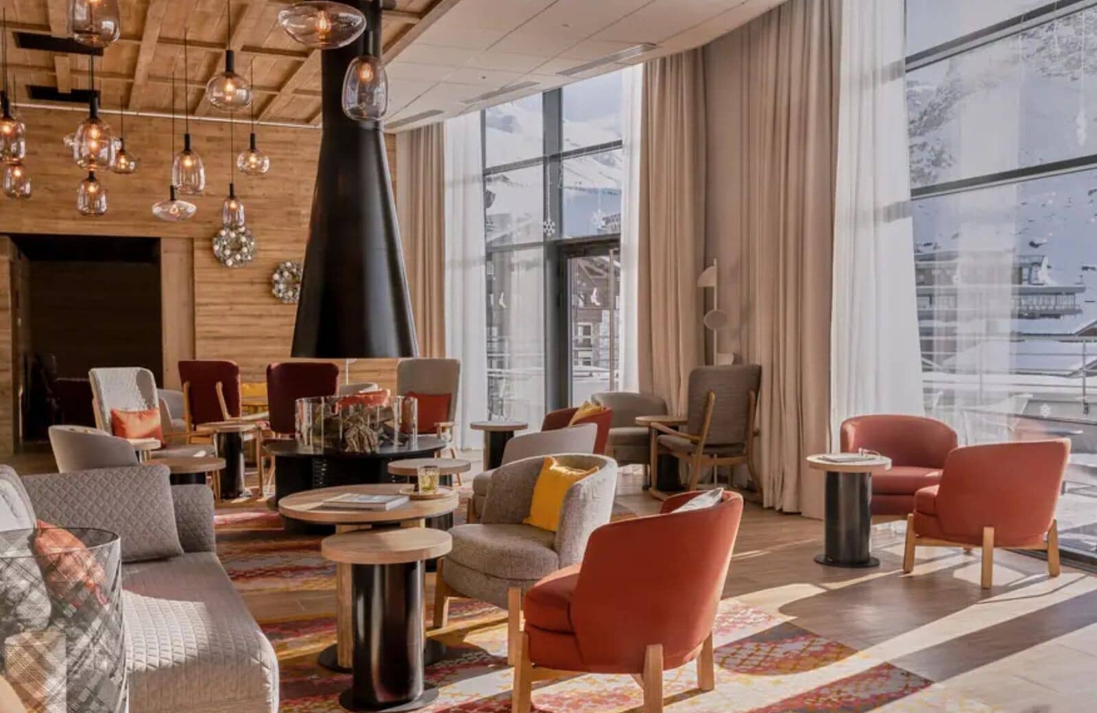 Lounge with central fireplace and floor-to-ceiling mountain views