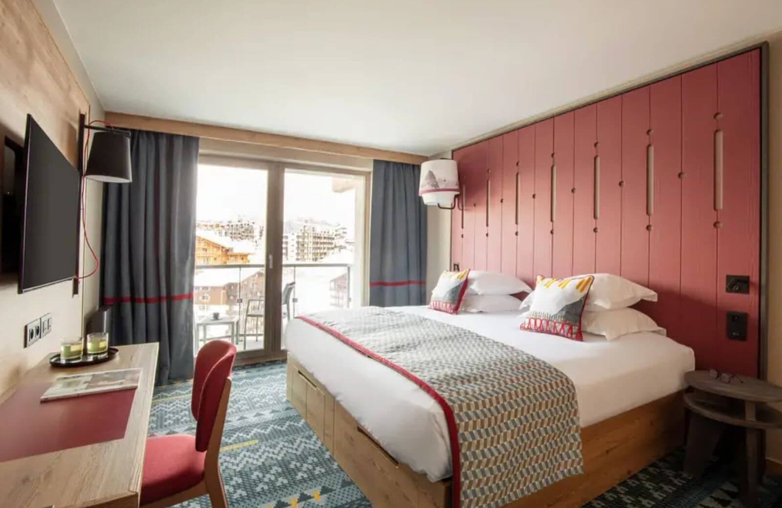 Bedroom with king bed, work desk, and balcony with mountain views