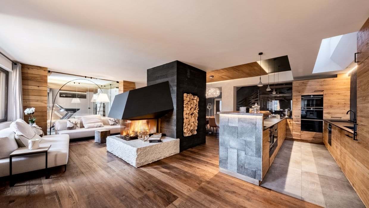 Open-plan living area with three-sided fireplace and full kitchen with double ovens