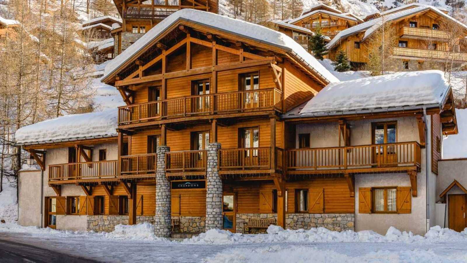 Ski-in/ski-out timber chalet with multiple private balconies and stone accents