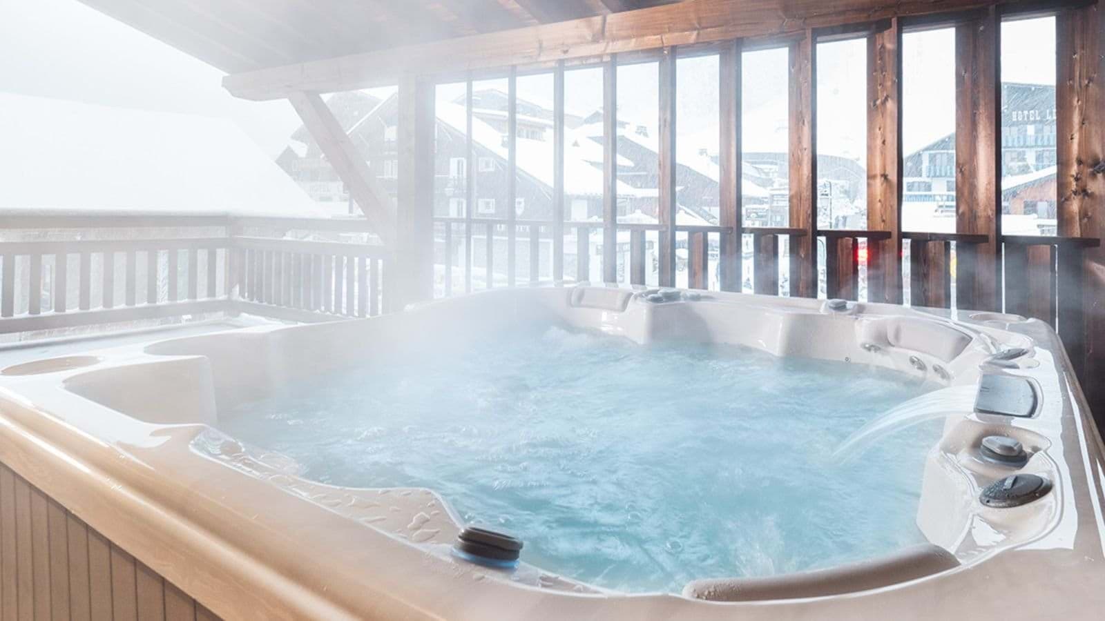 Covered outdoor hot tub seats 6 with village and mountain views