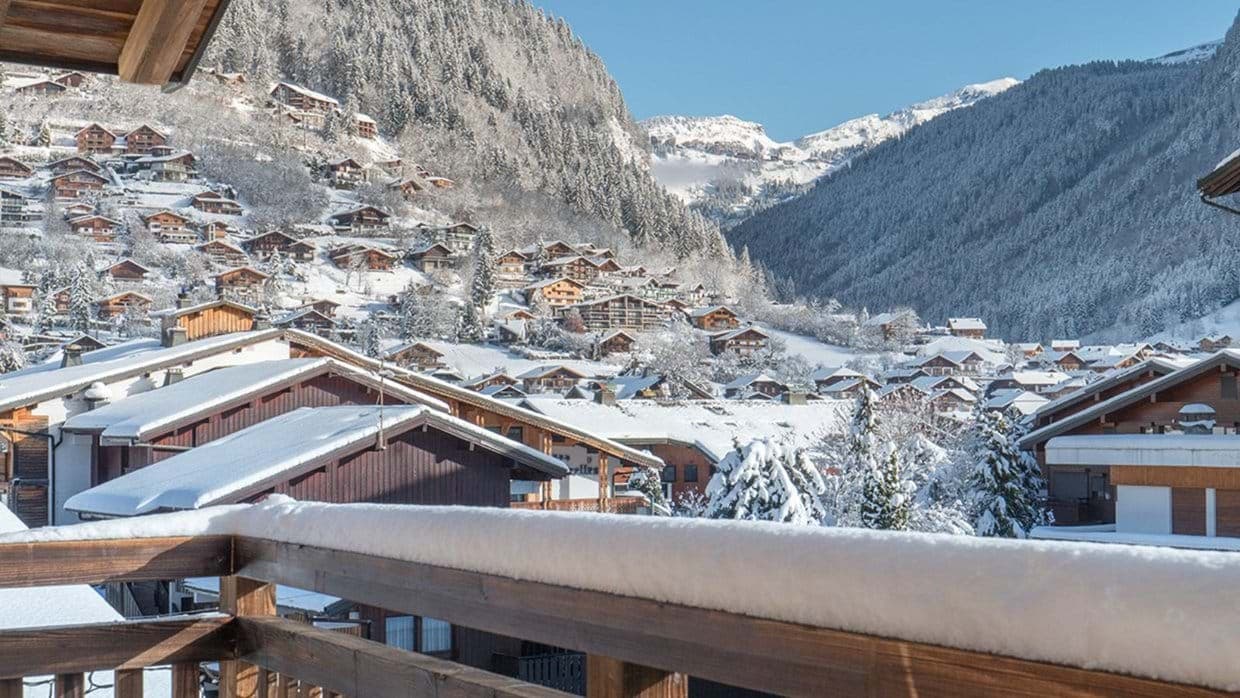 Private balcony overlooking the snow-covered alpine village and mountain valley