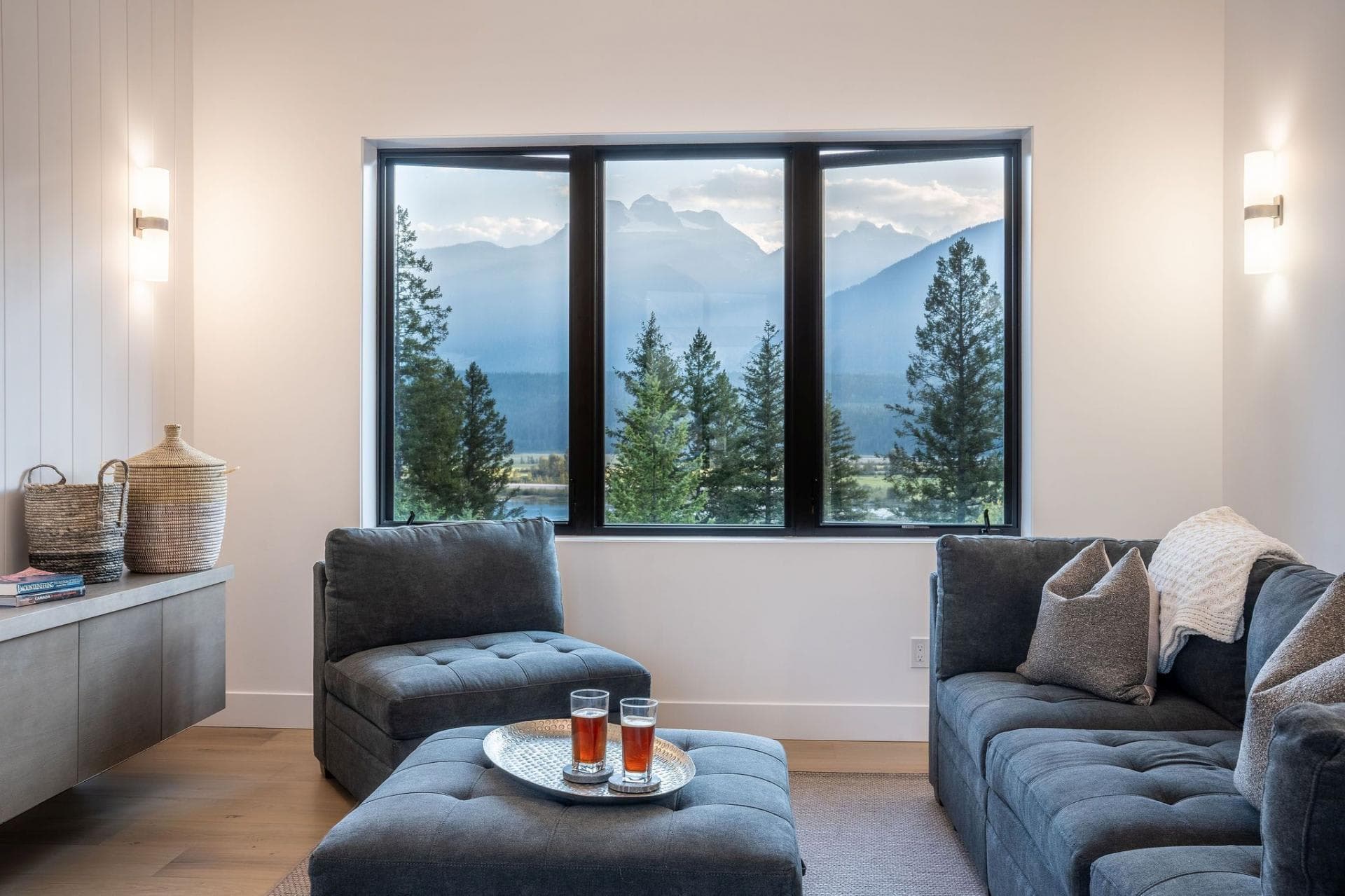 Living area with mountain views through triple-pane black frame windows