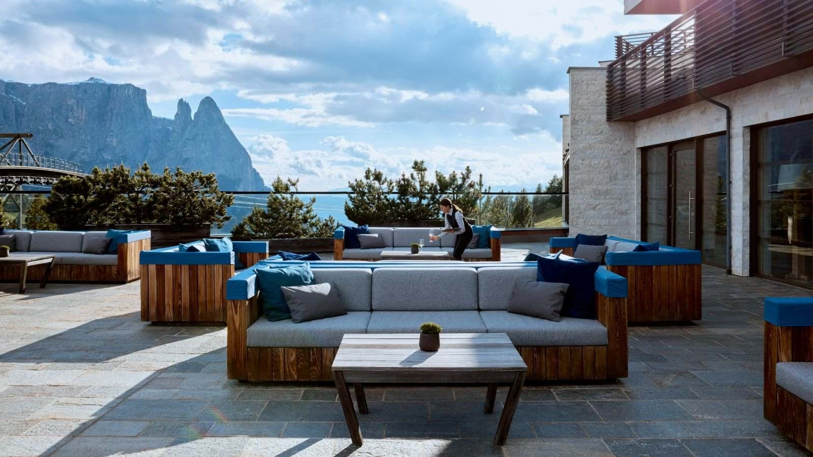 Stone terrace with lounge seating and Dolomites mountain views
