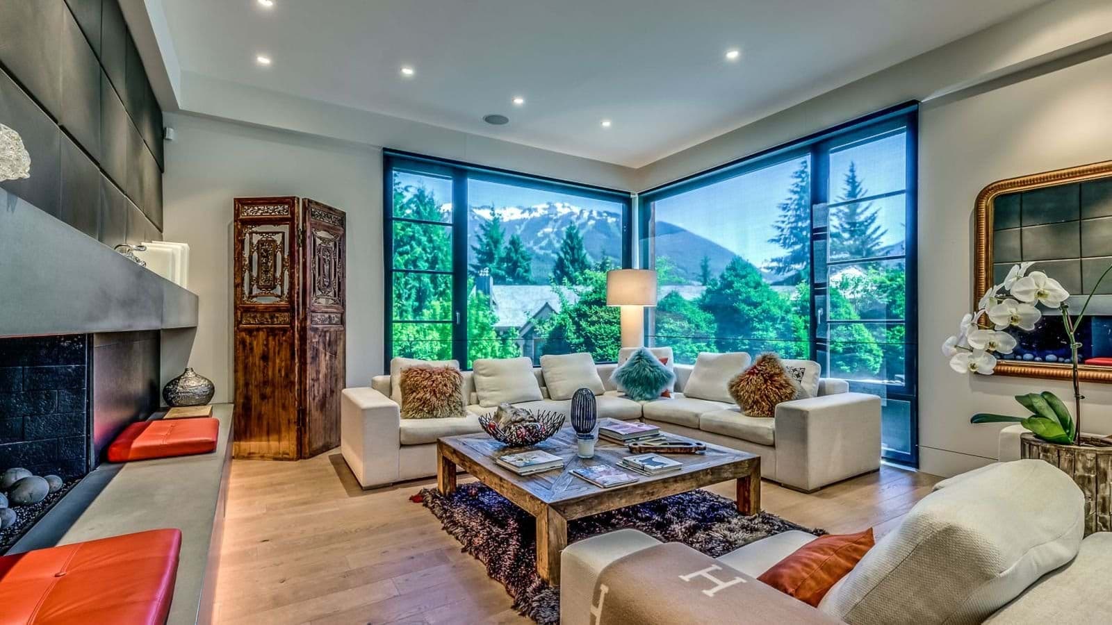 Living area with gas fireplace and corner windows showing mountain views