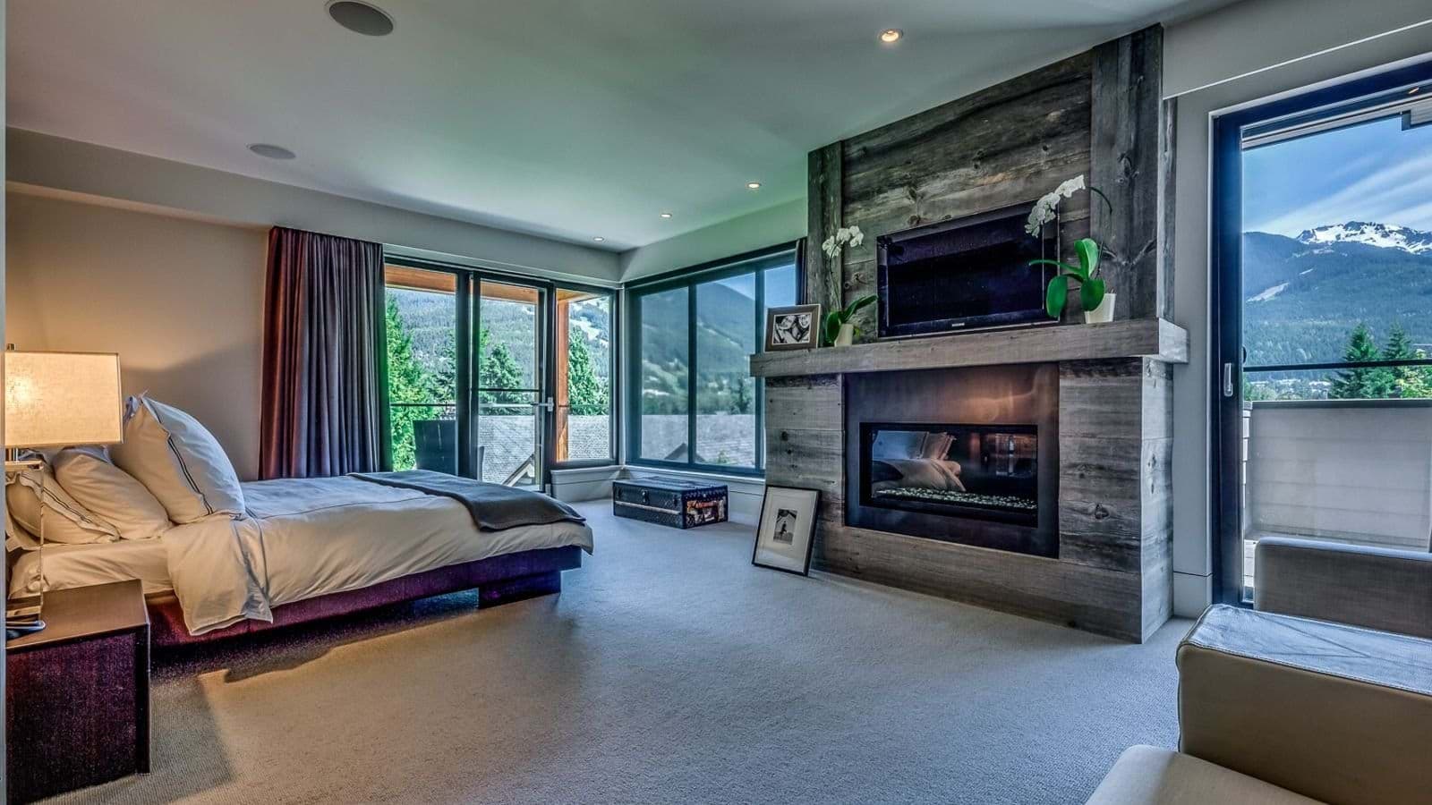 Primary bedroom with gas fireplace, king bed, and mountain views