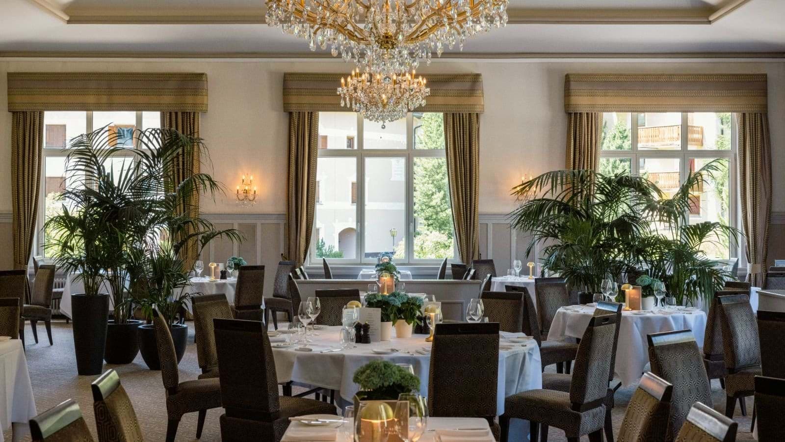 Formal dining room featuring white linens and crystal chandeliers