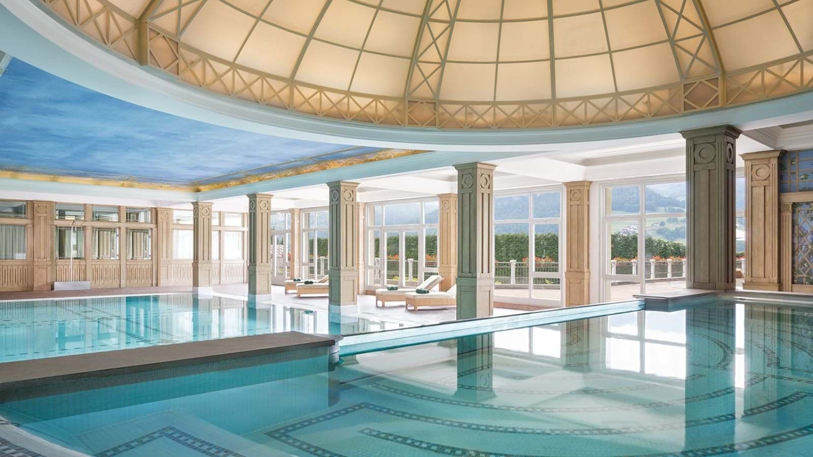 Indoor heated pool with domed skylight and mountain views