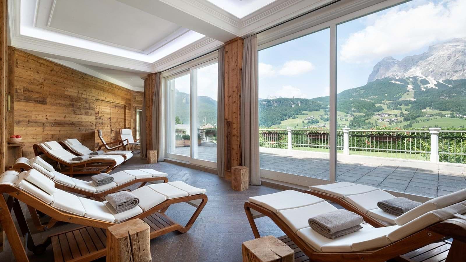Spa relaxation room with six loungers and panoramic Dolomite mountain views