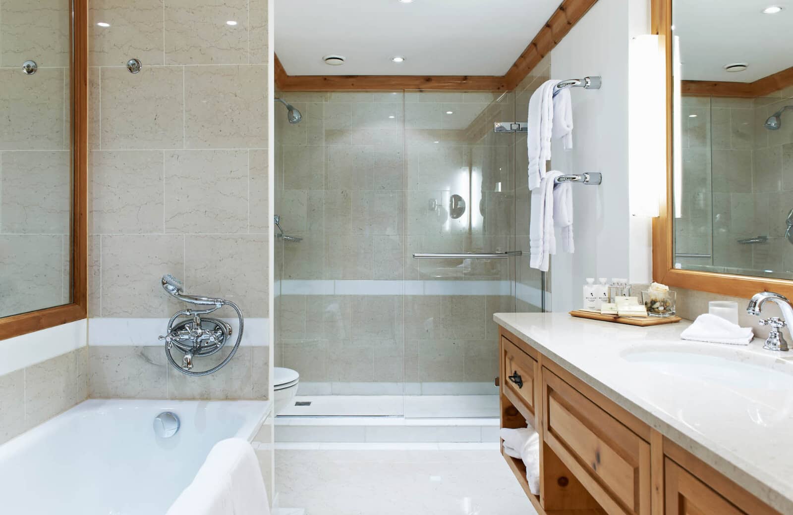 Primary bathroom with dual shower, soaking tub, heated towel racks, and wood beam ceiling