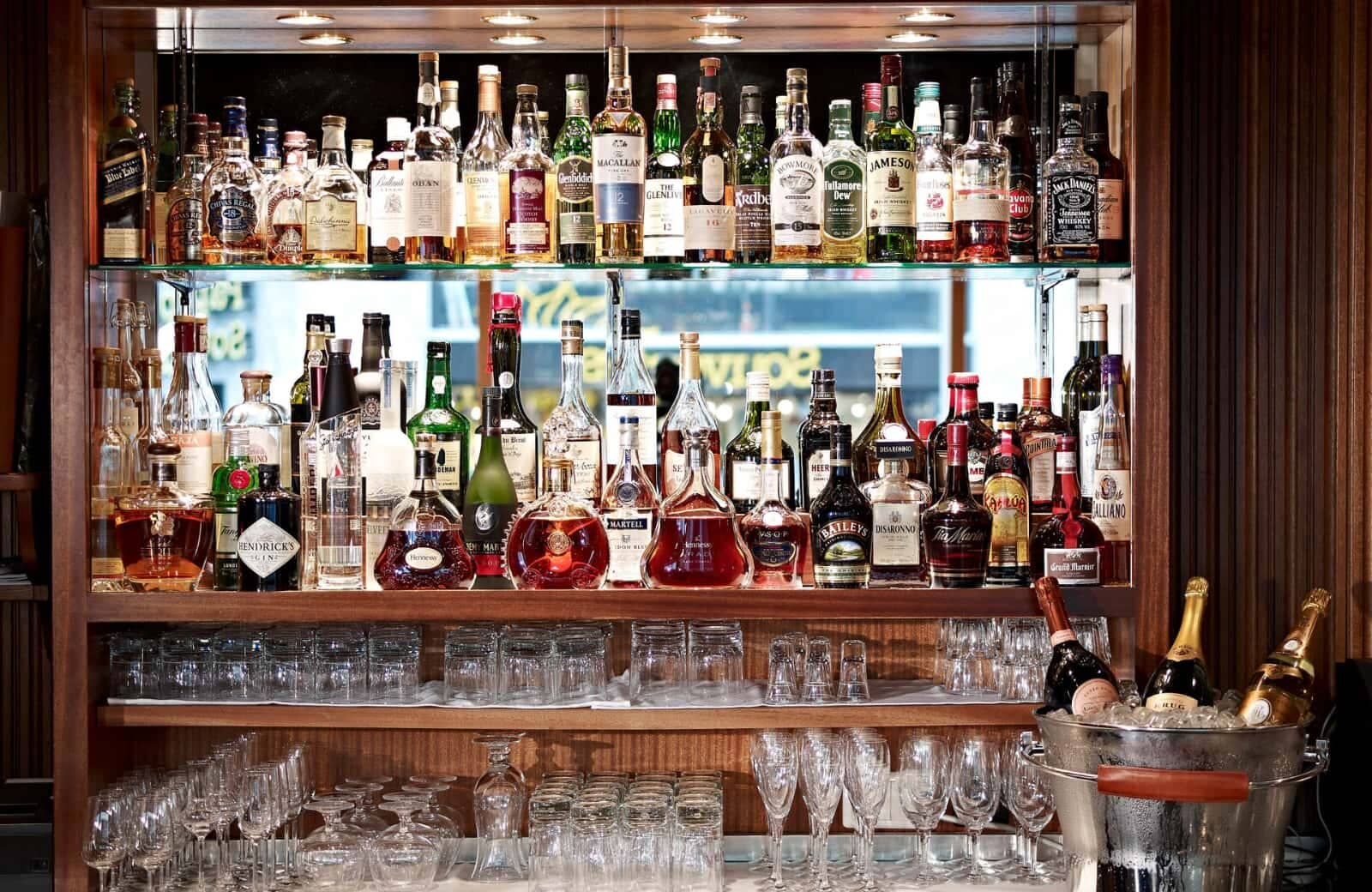 Stocked bar cabinet with spirits, wines, and glassware; seats 6+ at base