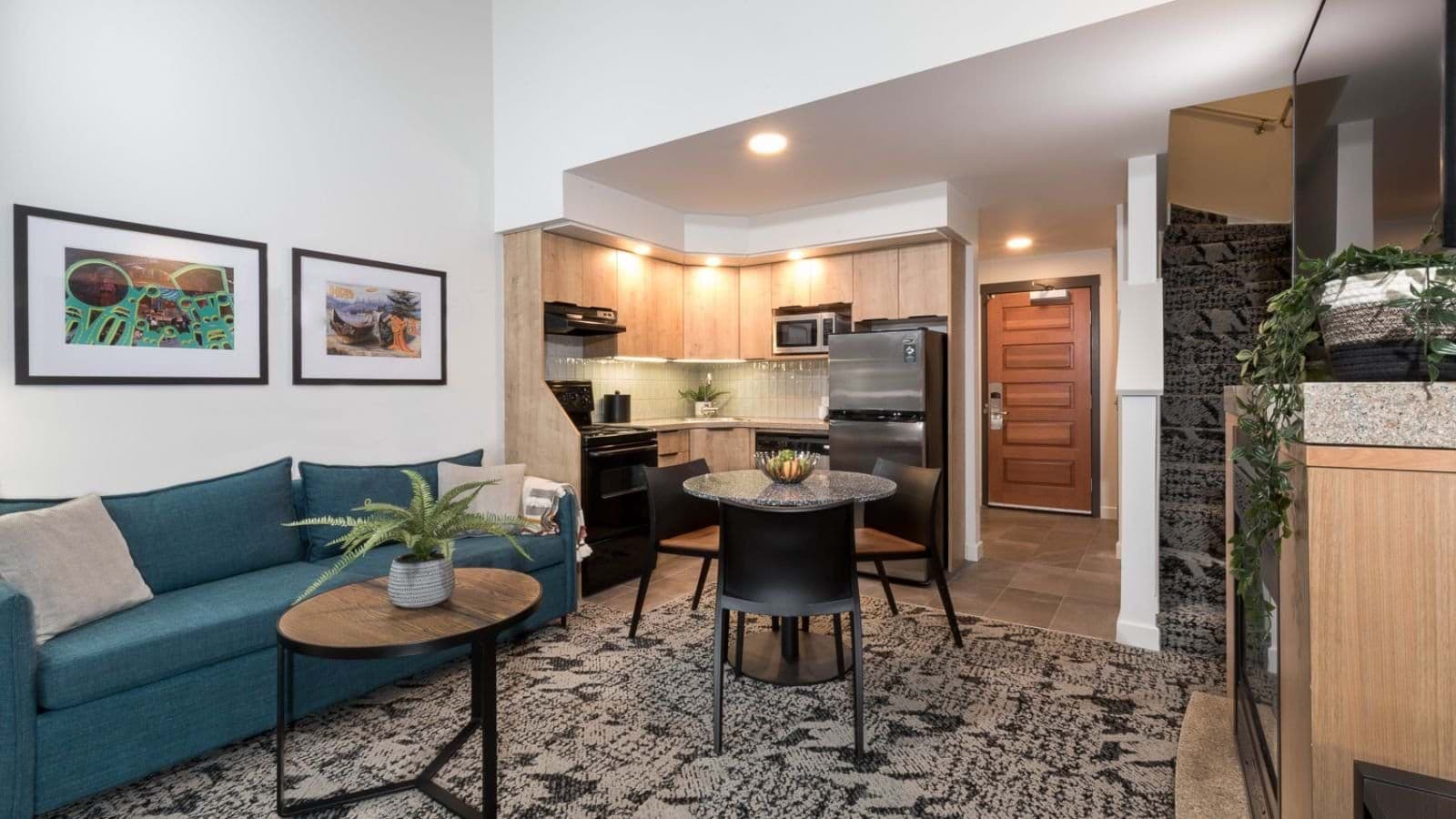 Open-plan living area with full kitchen and dining table for three
