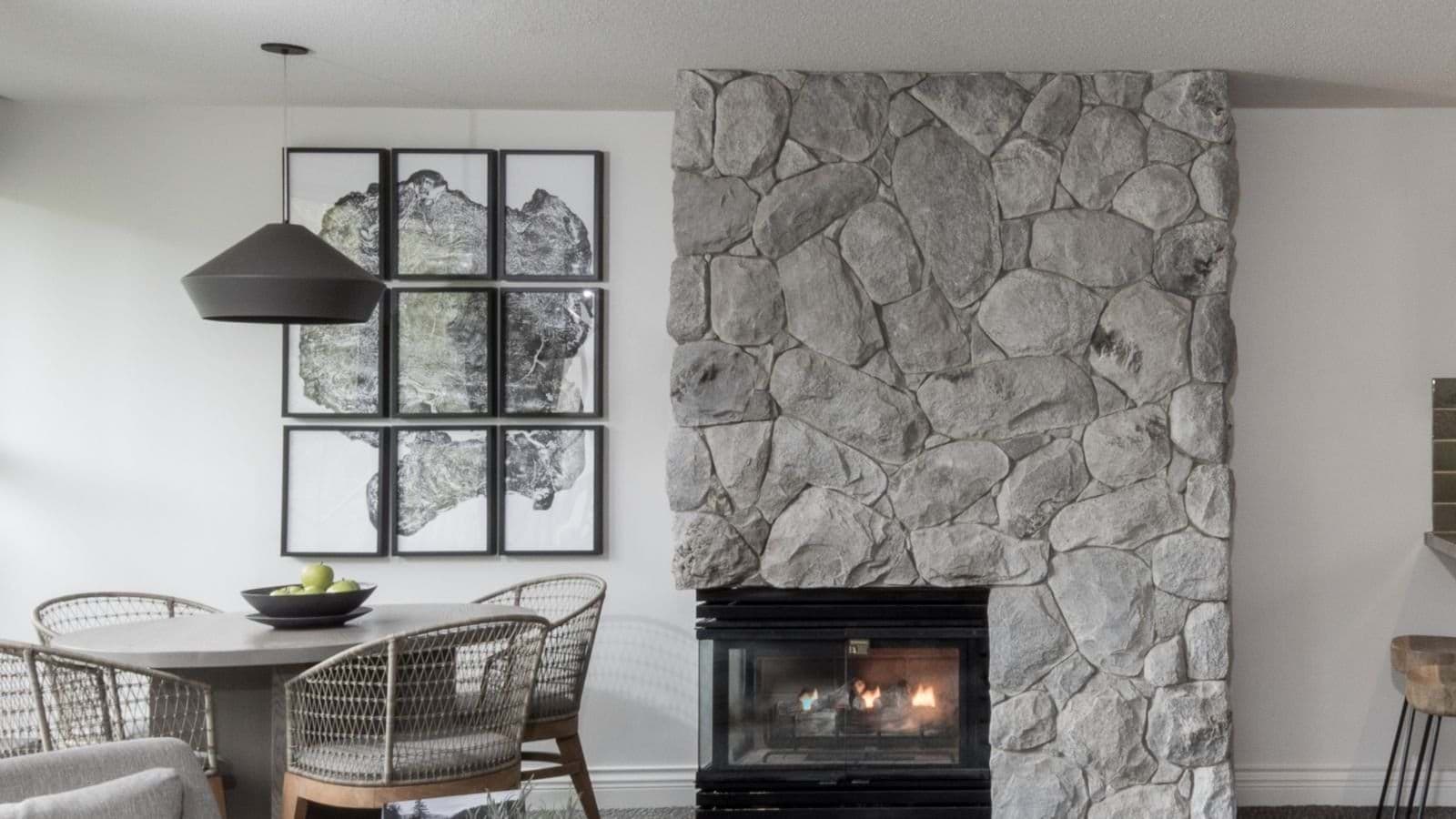 Stone-surround gas fireplace adjacent to dining table for four