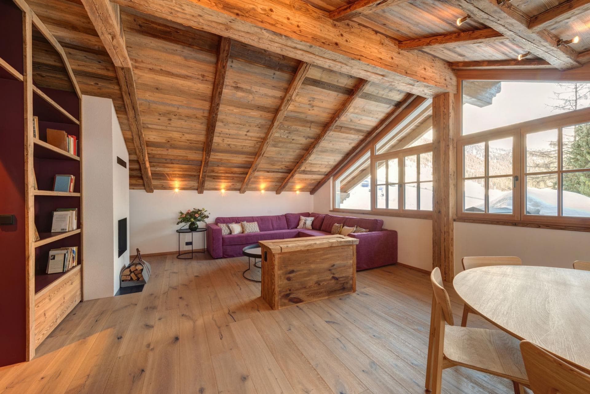 Open-plan living area with wood-burning fireplace and vaulted timber ceilings
