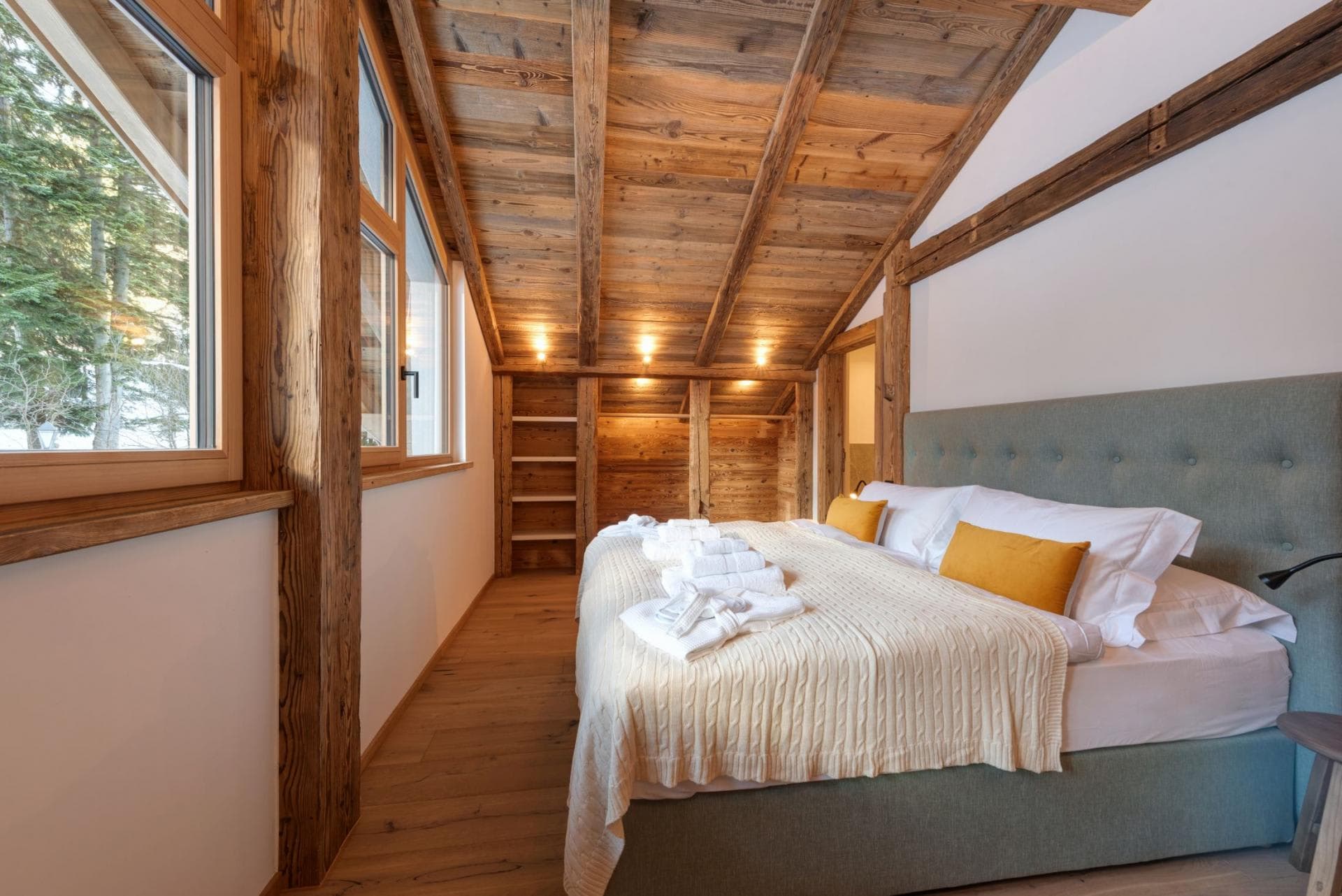 Top floor bedroom with king bed and built-in timber shelving