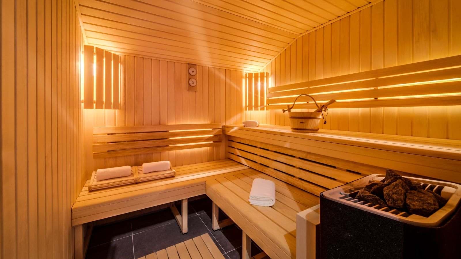 Private cedar sauna with tiered seating and electric rock heater