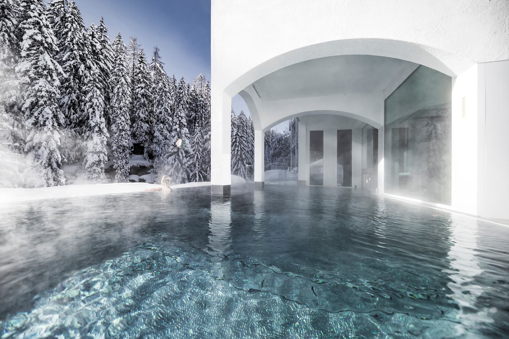 Heated infinity pool with forest views and swim-through indoor access