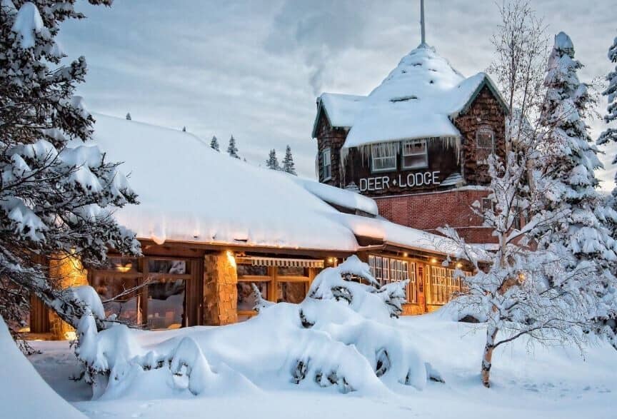 Deer Lodge exterior featuring stone architecture and snow-covered grounds