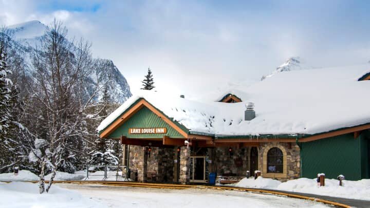 Lake Louise Inn lodge entrance with mountain views and guest pick-up area