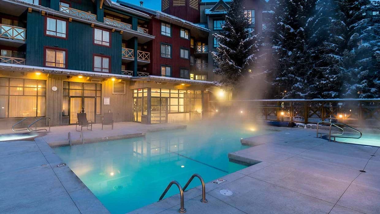 Heated outdoor pool and hot tubs with mountain resort views