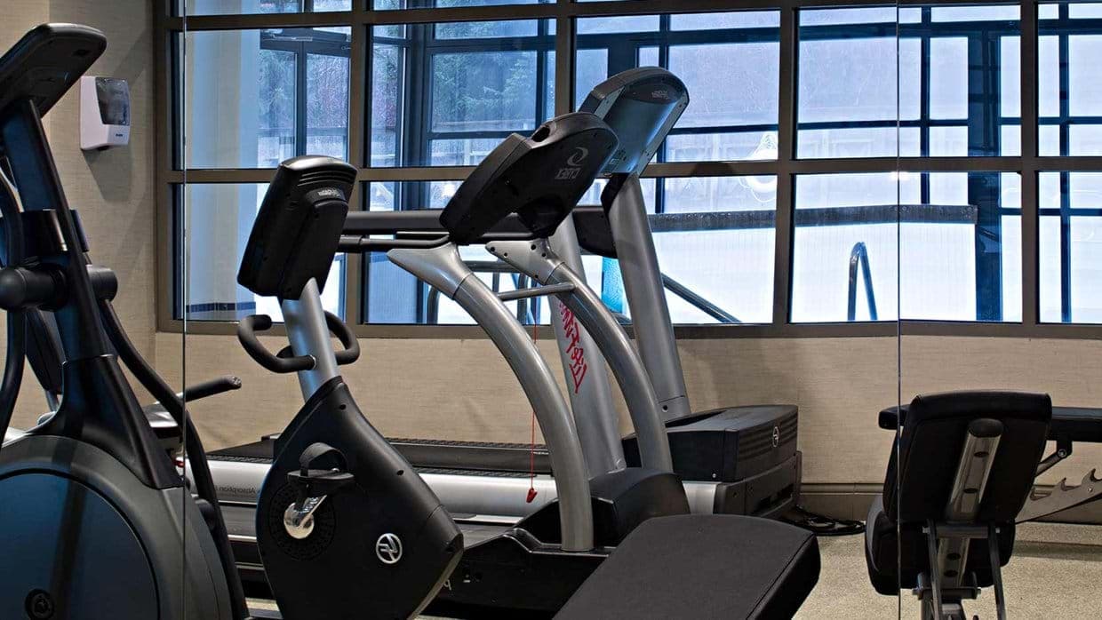 Fitness center with treadmills, stationary bikes, and pool views