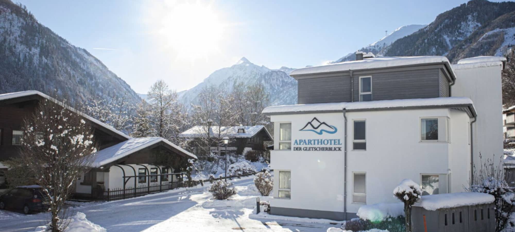Aparthotel exterior with mountain views and on-site parking