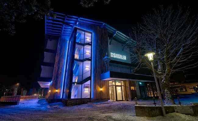 Hotel exterior at night with glass-enclosed stairwell and blue LED accents