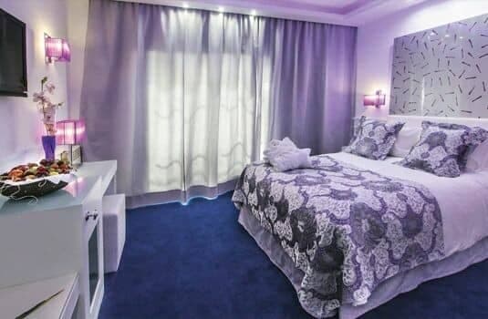 Guest bedroom with queen bed, vanity desk, and blackout curtains