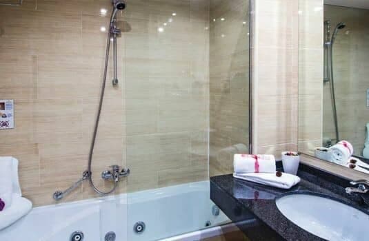 Bathroom with jetted soaking tub and handheld shower attachment