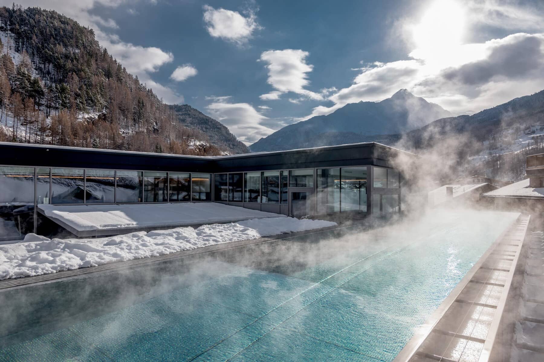 Heated infinity pool with mountain views and steam-venting water