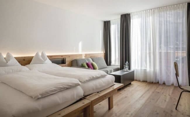 Guest bedroom with two twin beds and separate sofa seating area