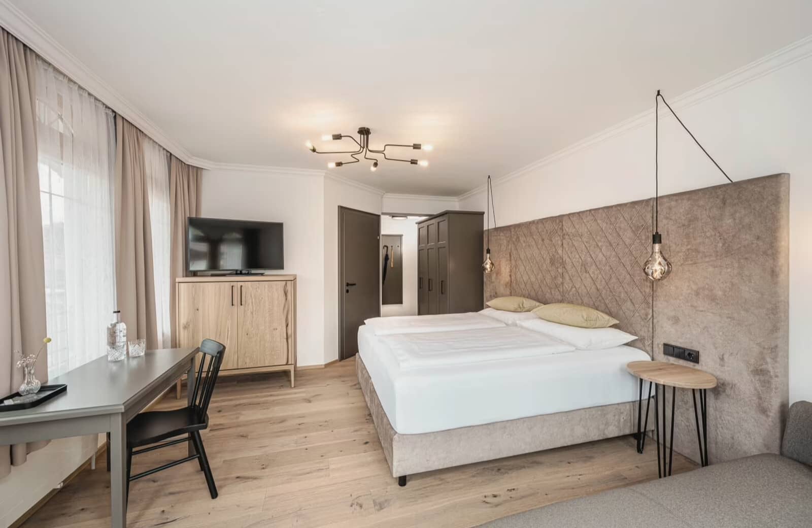 Primary bedroom with king bed, workstation, and smart TV