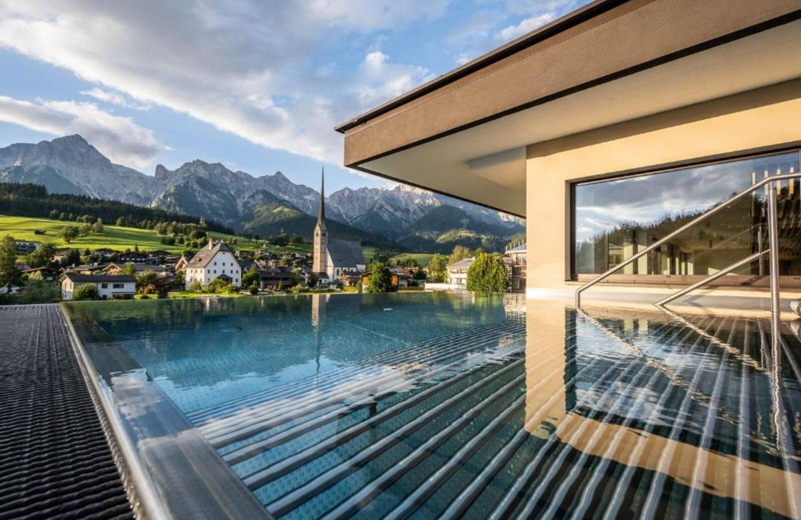 Rooftop infinity pool with village views and mountain backdrop