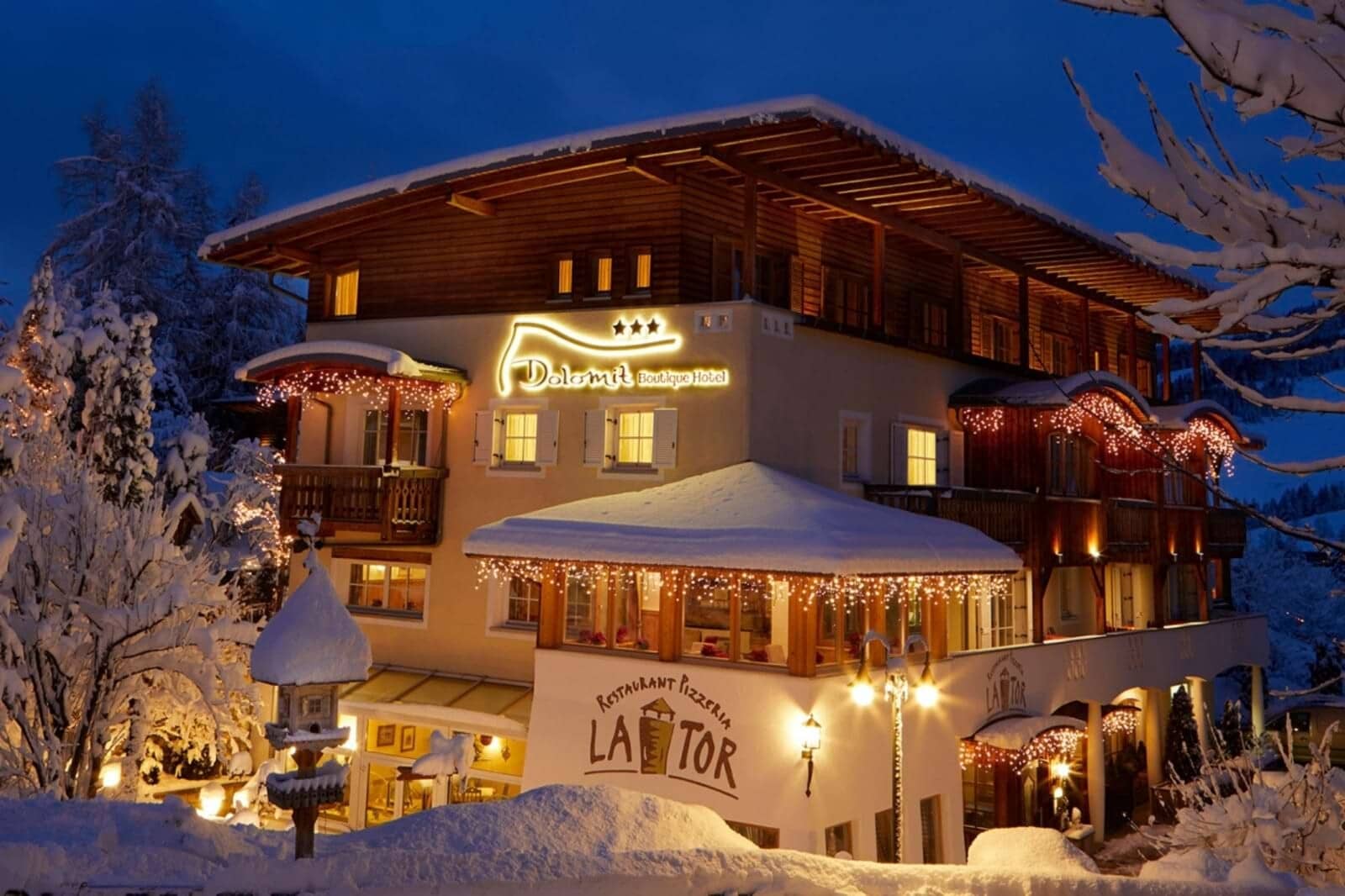 Boutique hotel exterior featuring on-site pizzeria and restaurant in winter