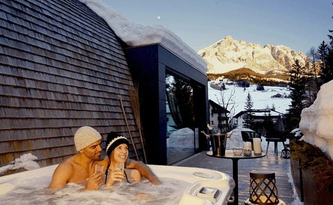 Private outdoor hot tub with mountain views and adjacent terrace seating