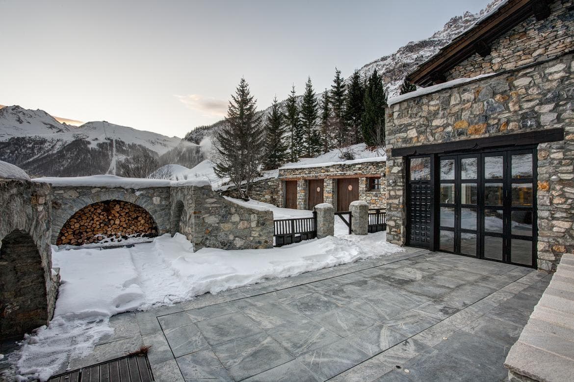 Stone patio with firewood storage and heated floor; mountain views