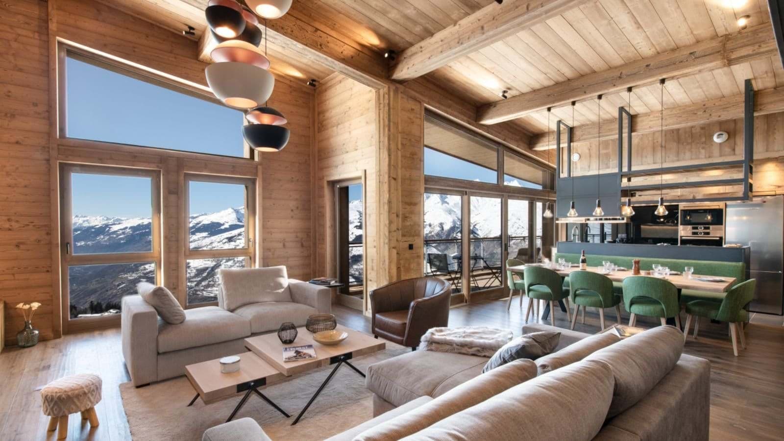 Open-plan living area with vaulted wood ceilings and panoramic Alpine views
