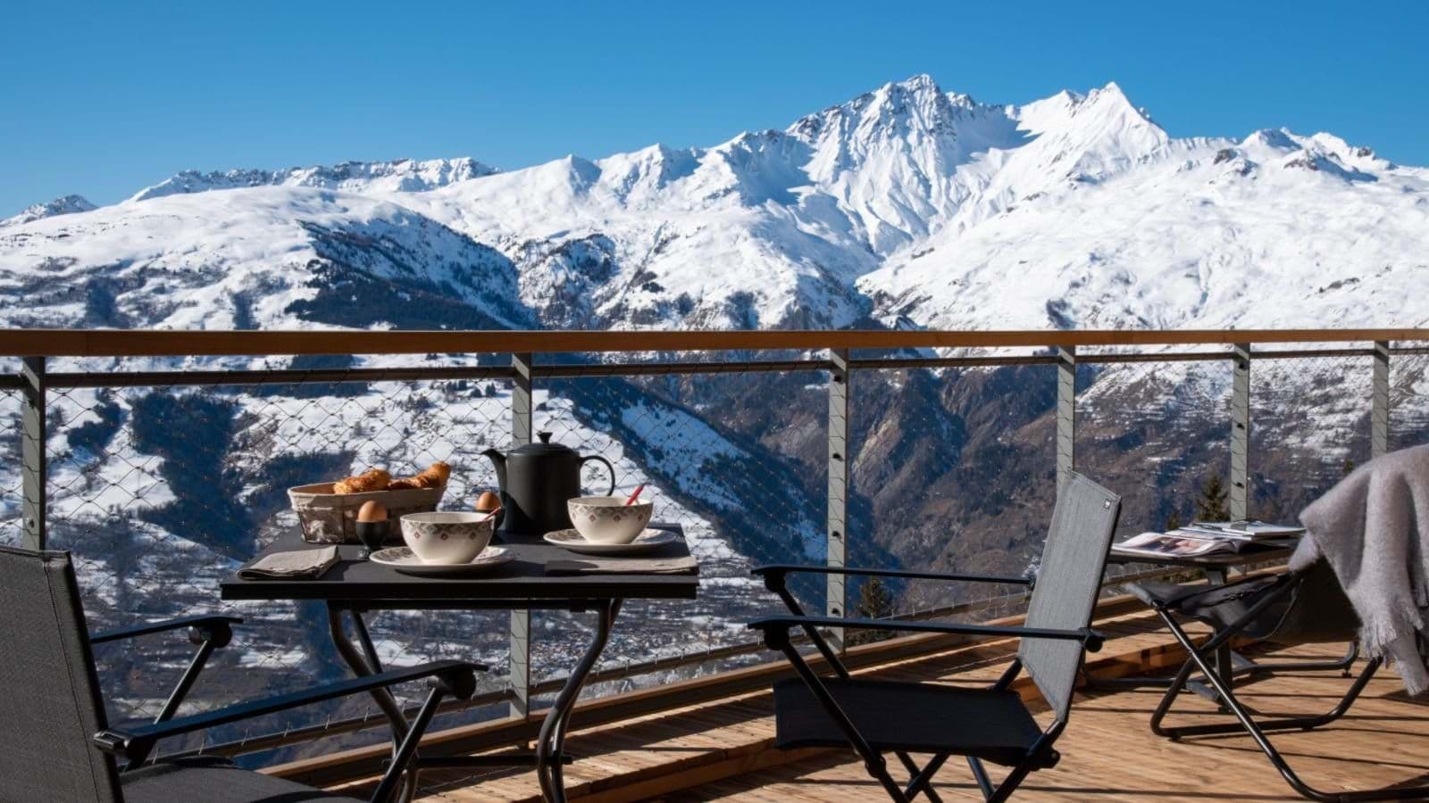 Private balcony with bistro seating and panoramic mountain range views