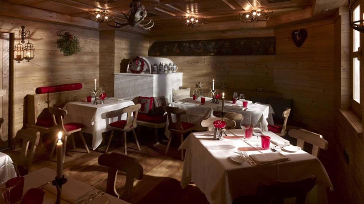 Dining room with wood-paneled walls and traditional masonry heater