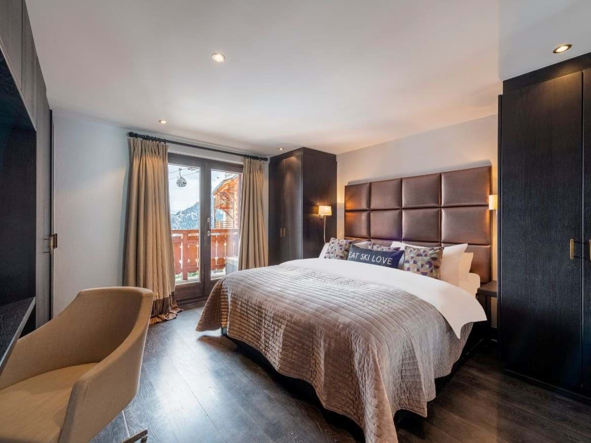 Primary bedroom with king bed and balcony views of ski gondola