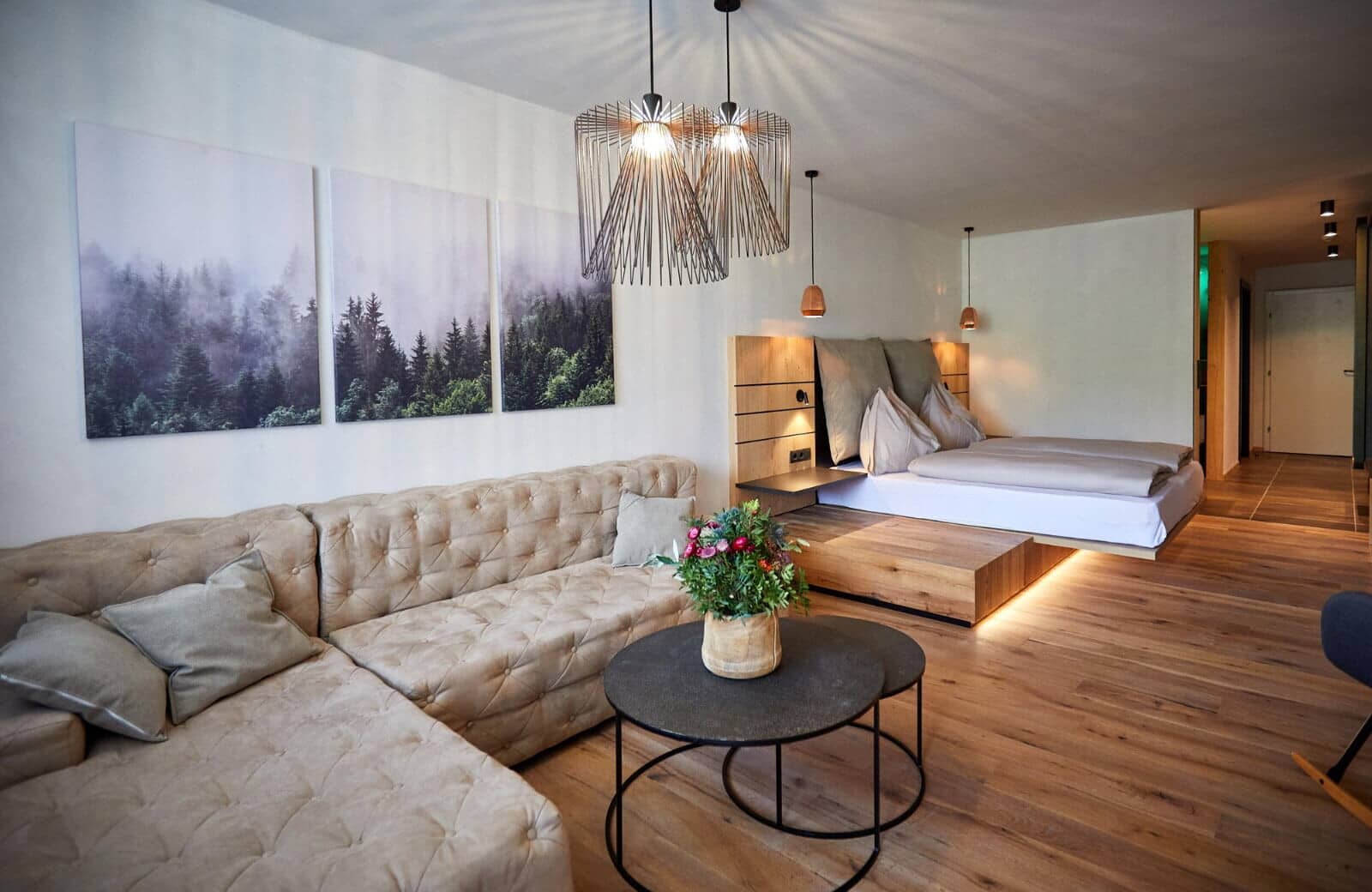 Studio living area with sectional sofa and elevated king-size platform bed