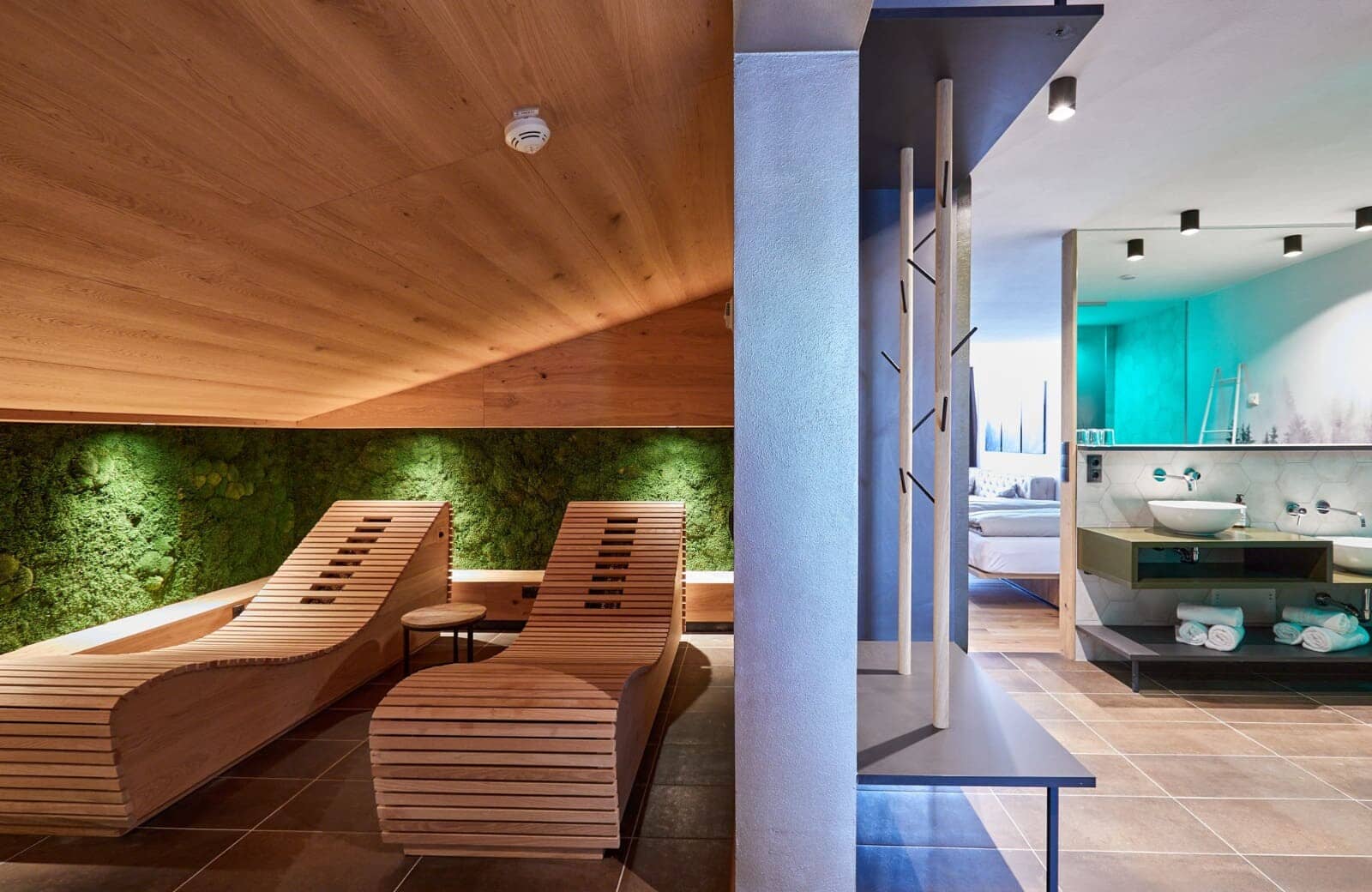 Spa area with ergonomic loungers, moss wall, and adjacent vanity