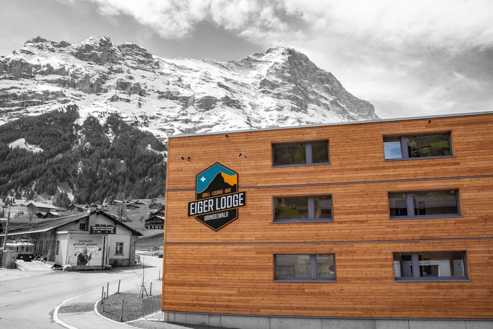 Lodge exterior featuring wood siding and mountain views; walking distance to train