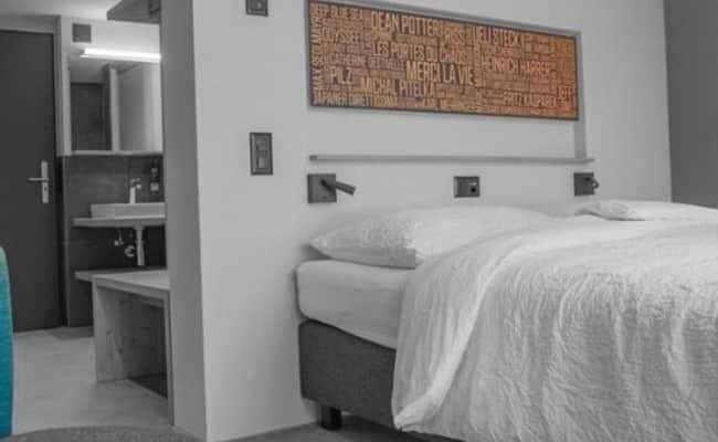 Guest bedroom with bedside reading lights and ensuite bathroom access