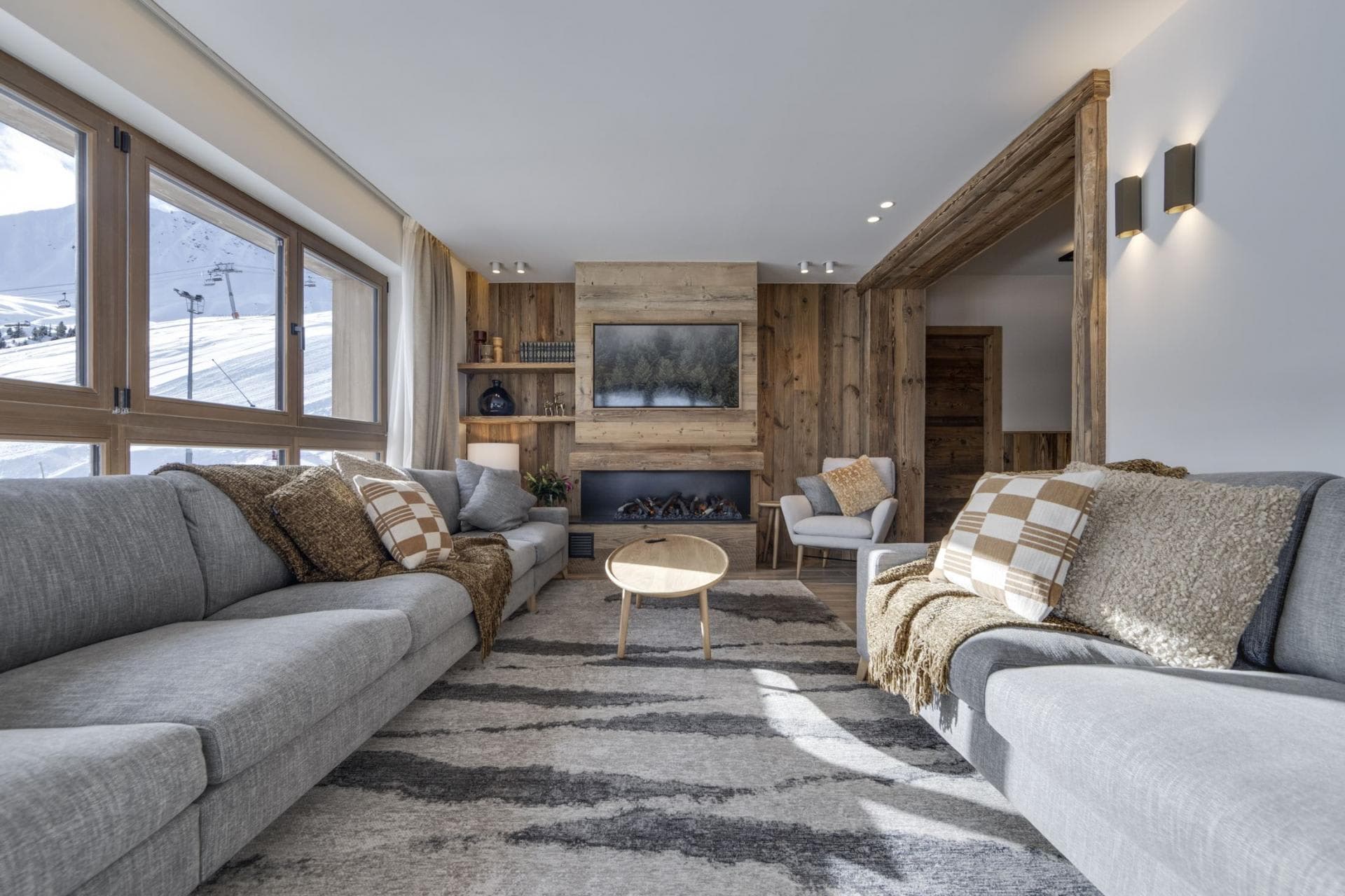 Living area with electric fireplace and ski-in/ski-out mountain views