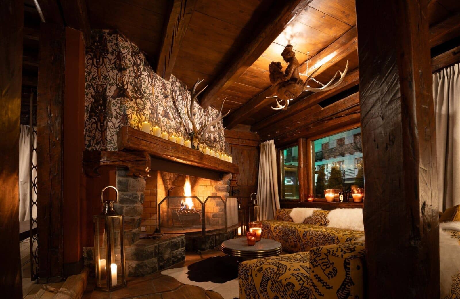 Lounge with wood-burning stone fireplace and exposed timber beams